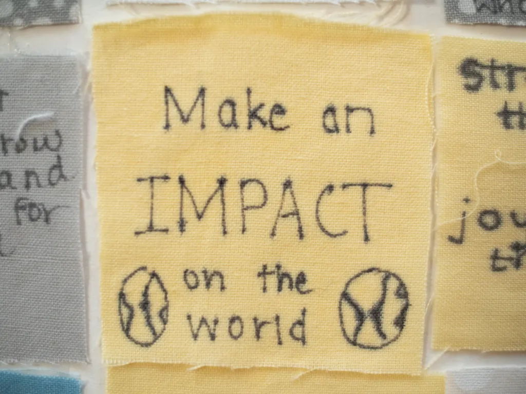 Close up of a senior quilt square that reads, "make an impact on the world."