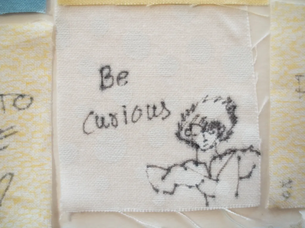 Close up of a senior quilt square that reads, "be curious."