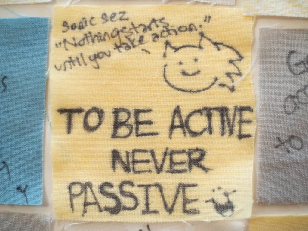 Close up of a senior quilt square that reads, "to be active never passive."