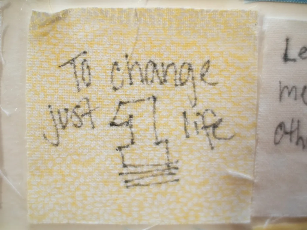 Close up of a senior quilt square that reads, "to change just one life."