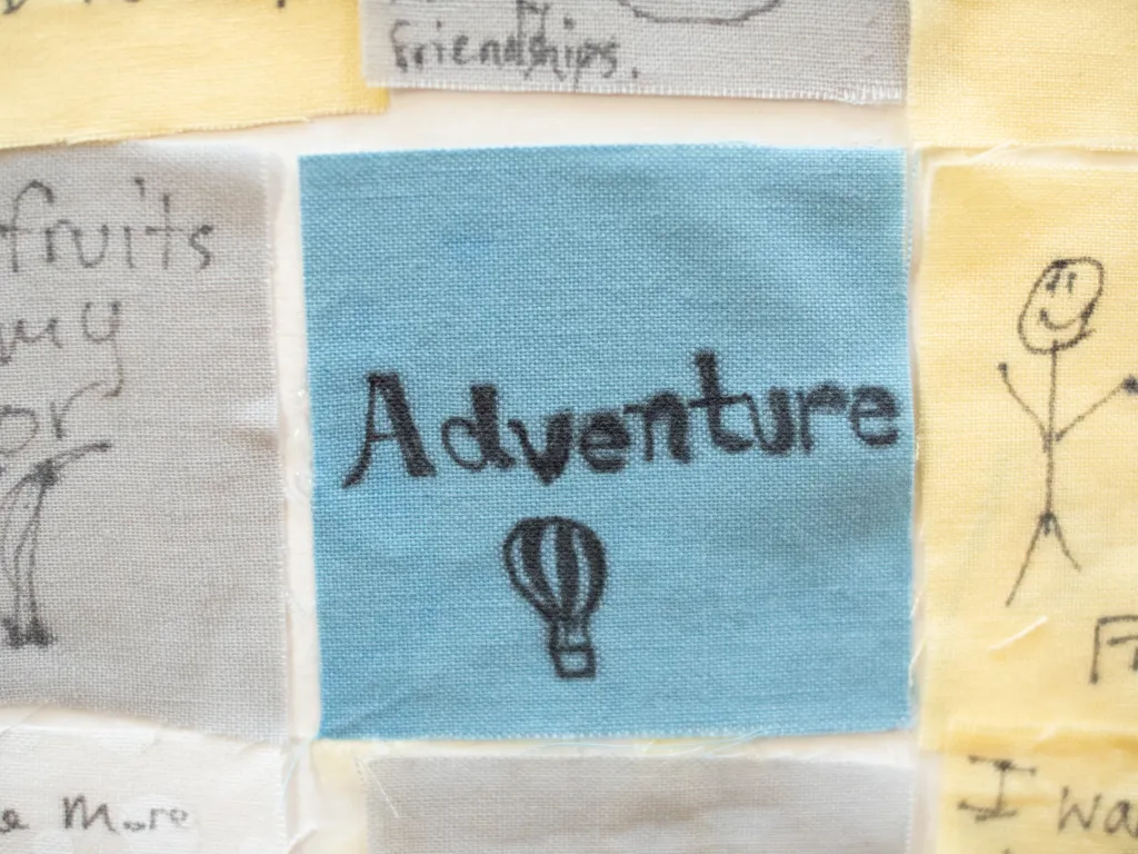 Close up of a senior quilt square that reads, "Adventure."