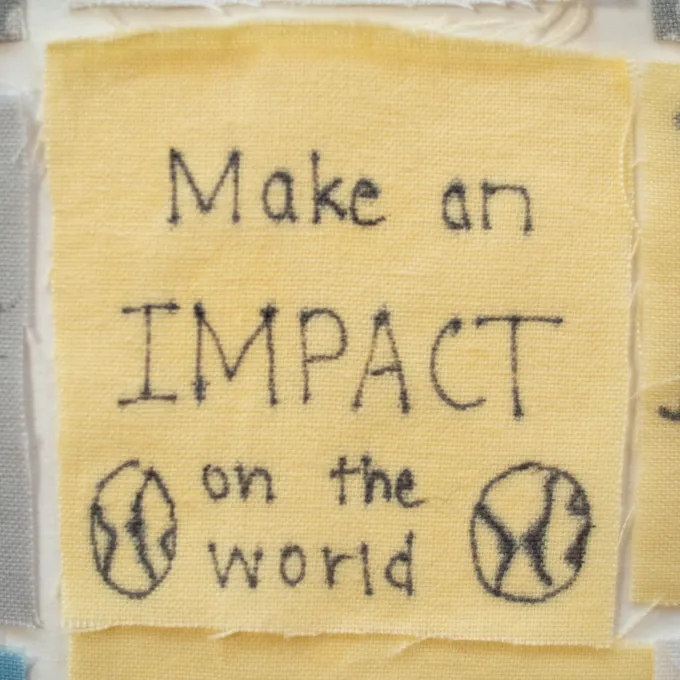Close up of a senior quilt square that reads, "make an impact on the world."