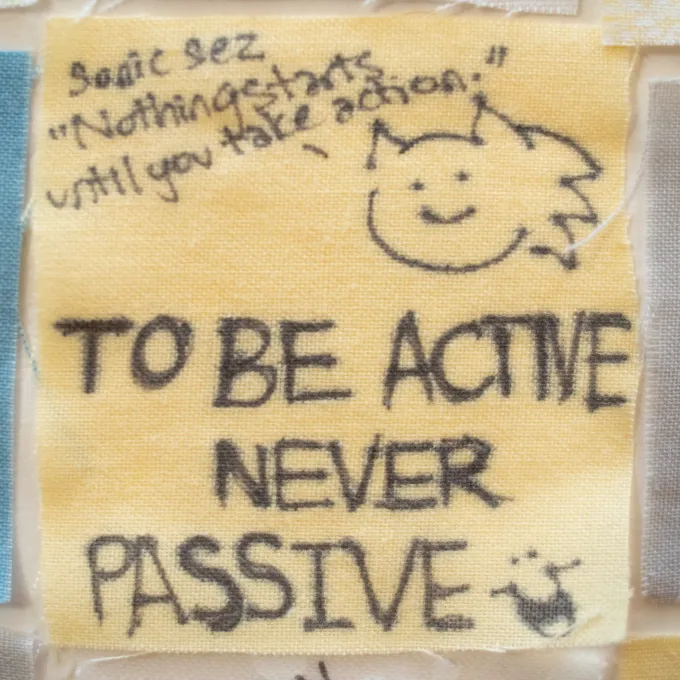Close up of a senior quilt square that reads, "to be active never passive."