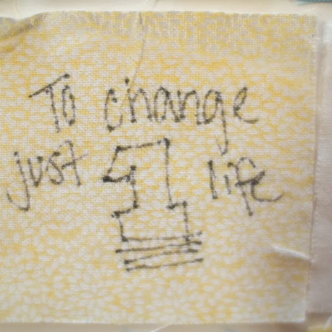 Close up of a senior quilt square that reads, "to change just one life."